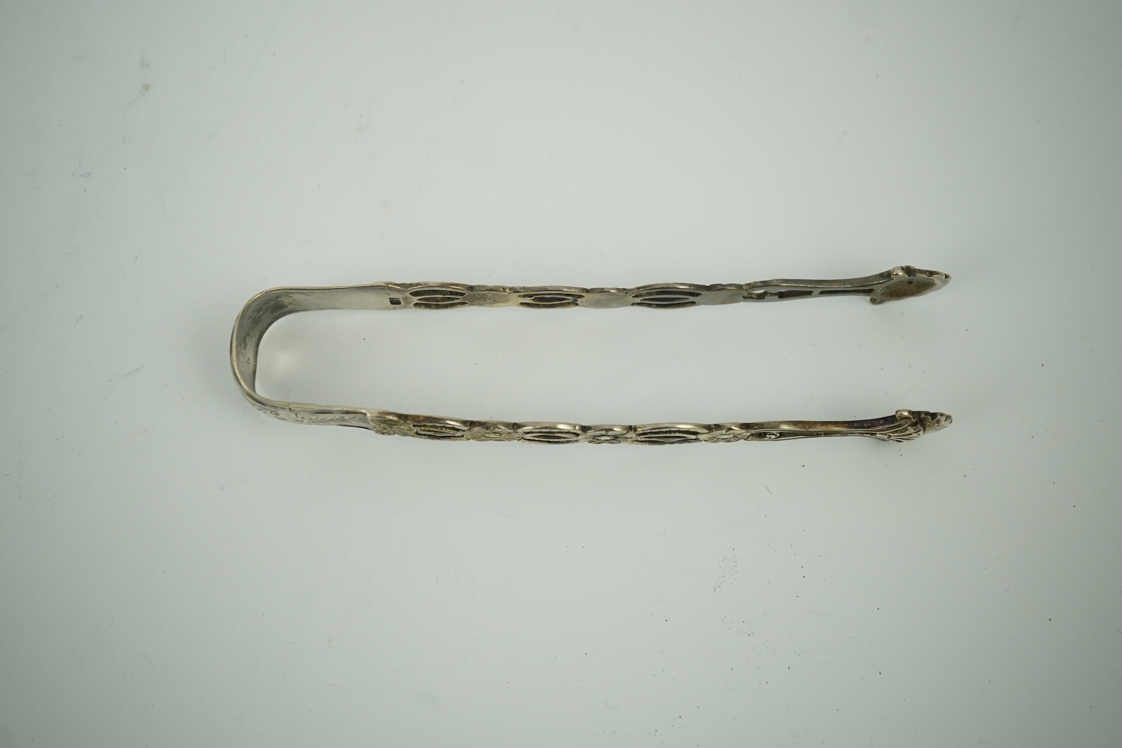 A pair of George III pierced silver tongs, makers mark only WC (repair), 13.1cm. Condition - poor